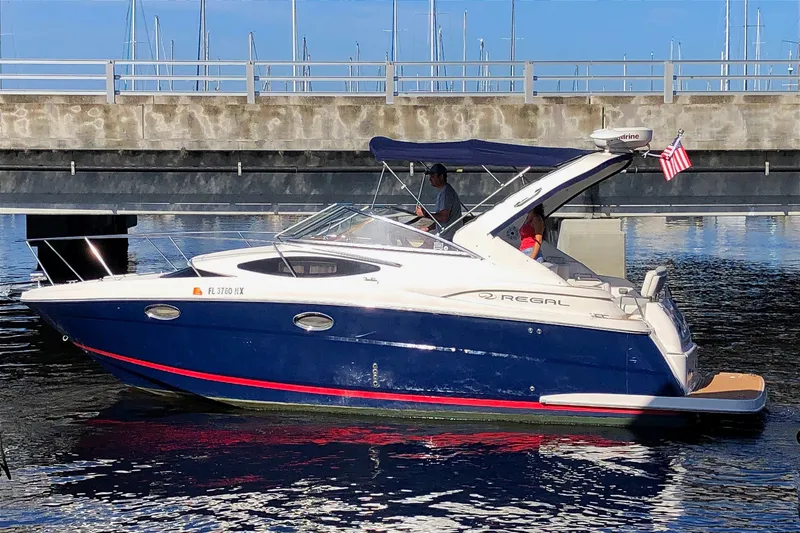 The Image of 2010 Regal 2860 Window Express boat docked, featuring sleek design and American flag. - 0