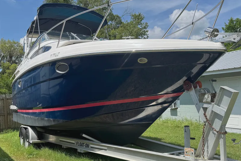 Slide: The Image of 2010 Regal 2860 Window Express boat on trailer, blue hull, parked outdoors. - 3