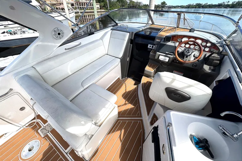 Slide: The Image of 2010 Regal 2860 Window Express boat interior with white seating and wooden accents. - 8