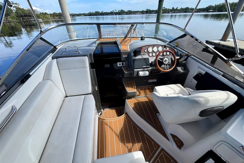 Slide: The Image of 2010 Regal 2860 Window Express boat interior with white seating and wooden accents. - 9