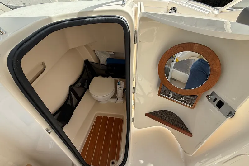 Slide: The Image of 2024 Grady-White Freedom 255 boat interior with compact bathroom and wooden accents. - 14