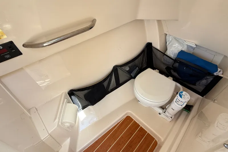 Slide: The Image of 2024 Grady-White Freedom 255 boat interior with compact marine toilet and storage. - 15
