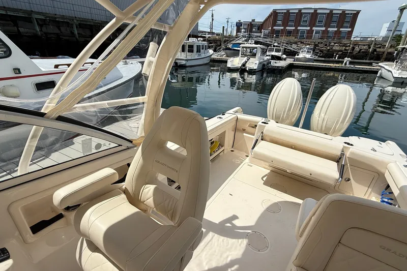 Slide: The Image of 2024 Grady-White Freedom 255 boat interior at marina, showcasing seating and helm. - 5