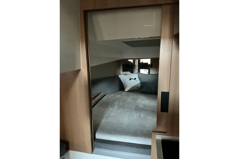 Slide: The Image of Interior cabin of 2027 NX Boats 41 Horizon, featuring a cozy bed and modern design. - 27
