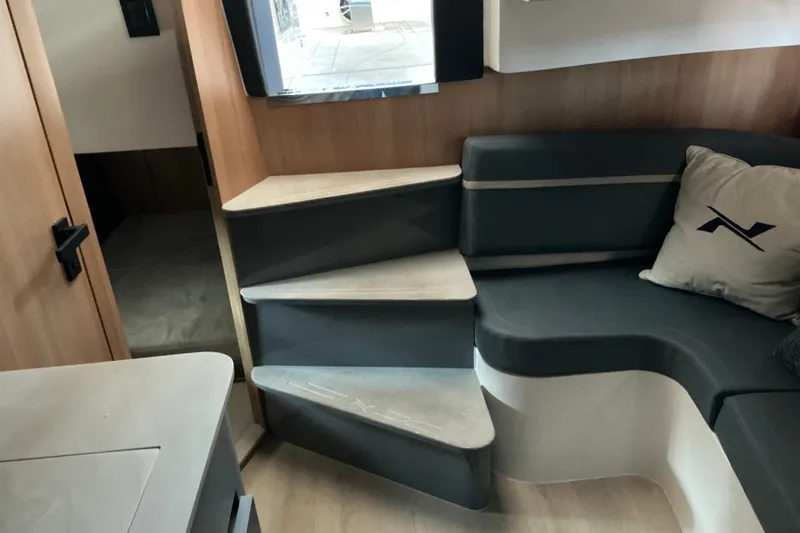 Slide: The Image of Interior of 2027 NX Boats 41 Horizon, featuring modern seating and stylish wooden steps. - 36