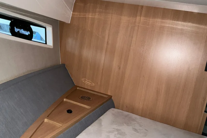 Slide: The Image of Interior cabin of 2027 NX Boats 41 Horizon, featuring wood paneling and a window. - 29