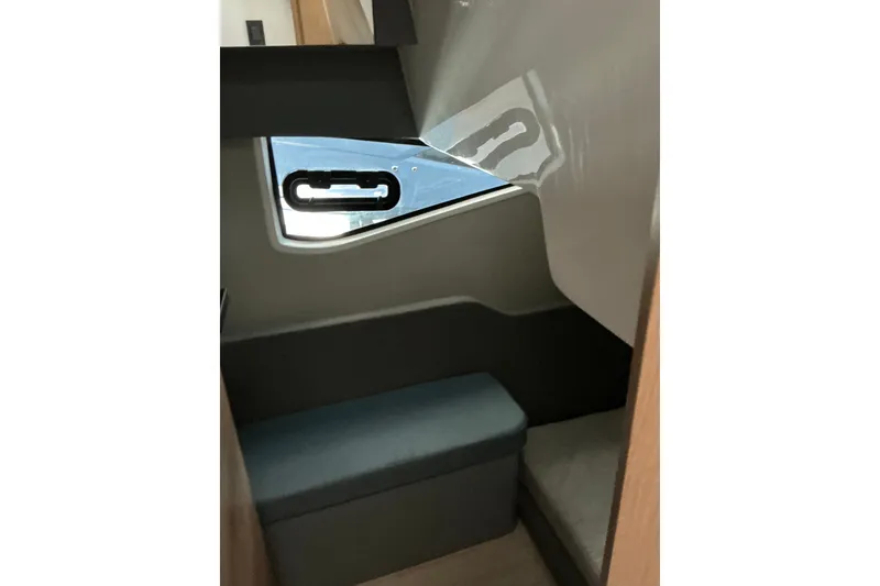 Slide: The Image of Interior cabin of 2027 NX Boats 41 Horizon, featuring a window and seating area. - 33