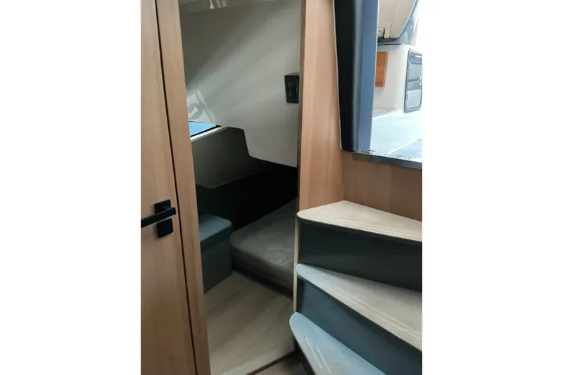 Slide: The Image of Interior view of 2027 NX Boats 41 Horizon cabin with wooden finishes and stairs. - 32