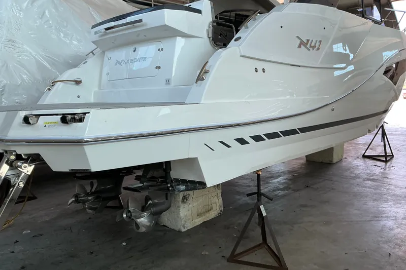 Slide: The Image of 2027 NX Boats 41 Horizon yacht in a workshop, showcasing sleek design and dual propellers. - 12