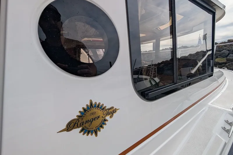 Slide: The Image of 2023 Ranger Tugs boat exterior with logo and window reflection. - 31