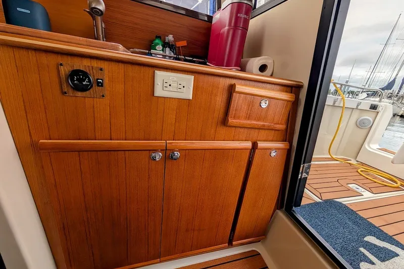 Slide: The Image of 2023 Ranger Tugs boat interior with wooden cabinetry and a Keurig coffee maker. - 16