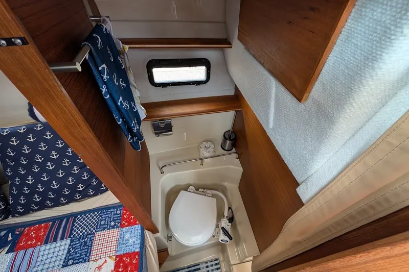 Slide: The Image of 2023 Ranger Tugs boat interior with compact bathroom and nautical-themed decor. - 10