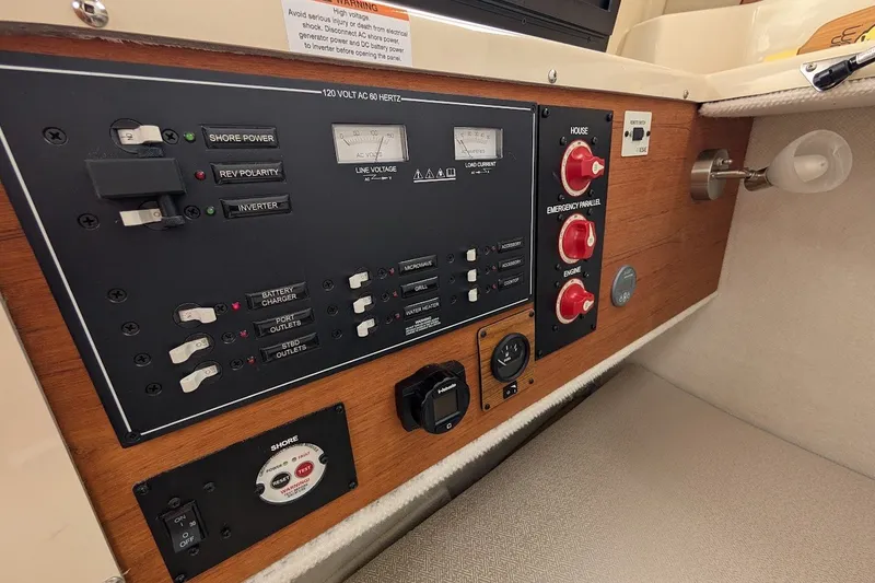 Slide: The Image of 2023 Ranger Tugs electrical control panel with switches and gauges on a wooden surface. - 37