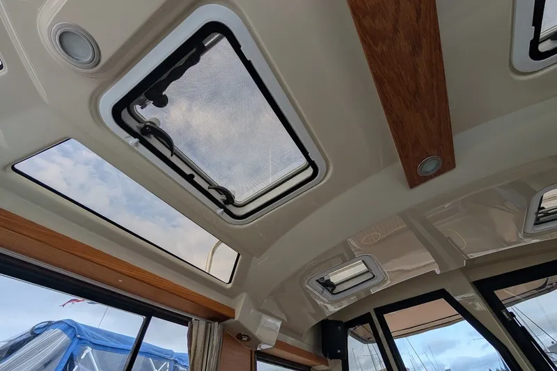 Slide: The Image of Interior view of 2023 Ranger Tugs boat ceiling with skylights and wood accents. - 11