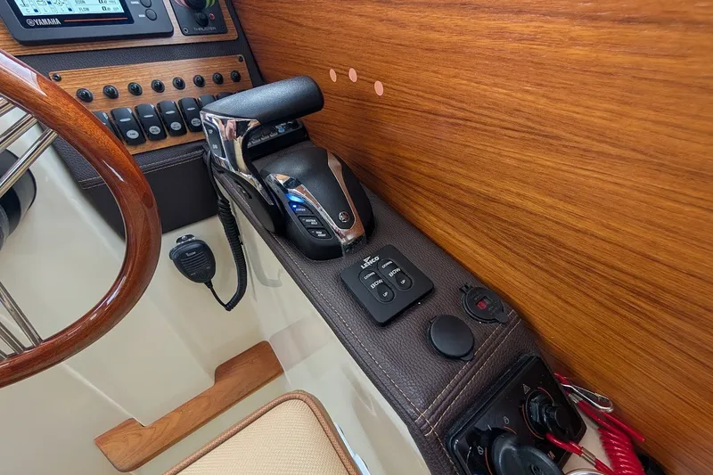 Slide: The Image of 2023 Ranger Tugs helm with wooden accents, throttle controls, and navigation equipment. - 7