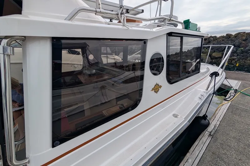 Slide: The Image of 2023 Ranger Tugs boat docked, showcasing sleek design and large windows. - 27