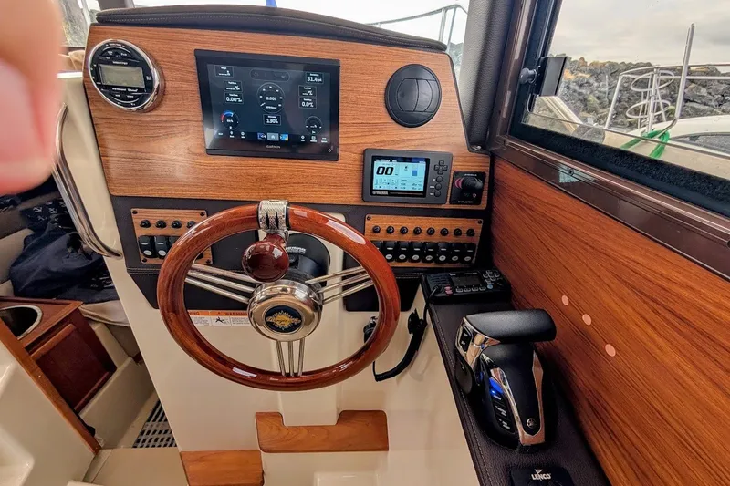 Slide: The Image of 2023 Ranger Tugs helm with wooden dashboard, modern controls, and navigation display. - 6