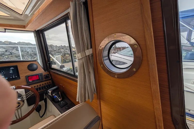 Slide: The Image of Interior of 2023 Ranger Tugs boat with wooden paneling and porthole window. - 8