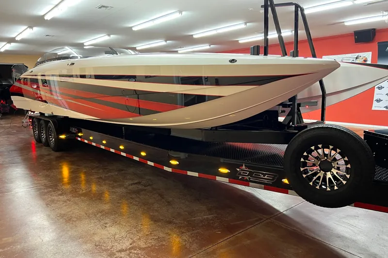 Slide: The Image of 2023 Daves Custom Boats M37R on trailer, featuring sleek design and vibrant red accents. - 2