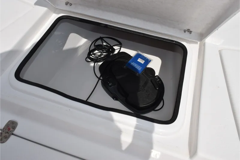 Slide: The Image of Open storage compartment on 2020 Sportsman Tournament 214 Bay Boat with coiled cable. - 16