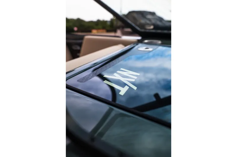Slide: The Image of 2027 MasterCraft NXT24 boat windshield reflecting sky and surroundings. - 29