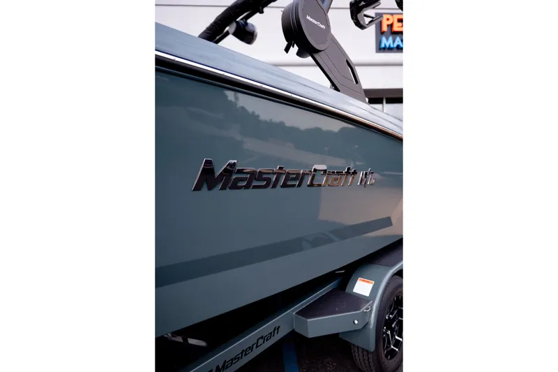 Slide: The Image of 2027 MasterCraft NXT24 boat side view with logo and trailer detail. - 15