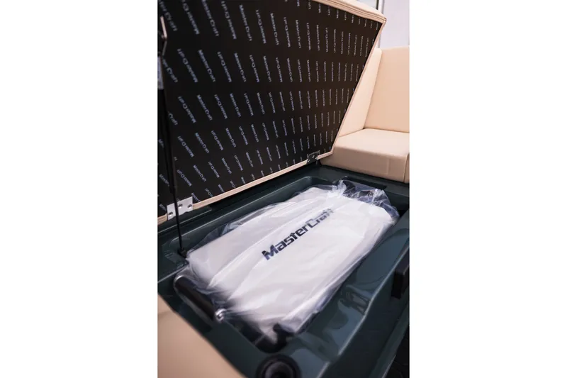 Slide: The Image of Storage compartment of 2027 MasterCraft NXT24 boat with branded cover inside. - 38