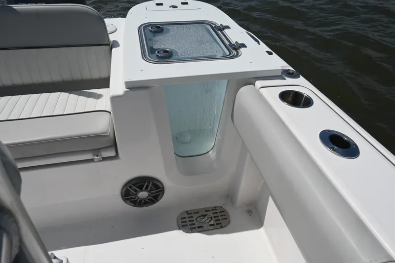 Slide: The Image of 2024 Sea Fox 228 Commander boat interior with seating, cup holders, and storage compartment. - 23