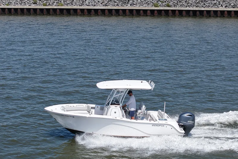 Slide: The Image of A white 2024 Sea Fox 228 Commander boat cruises on calm water with an outboard motor. - 10