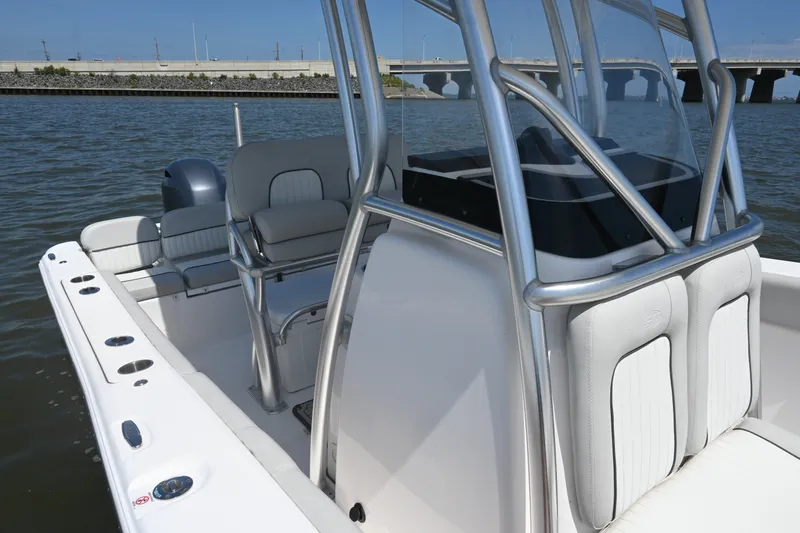 Slide: The Image of 2024 Sea Fox 228 Commander boat interior with seating and console, docked on calm water. - 17