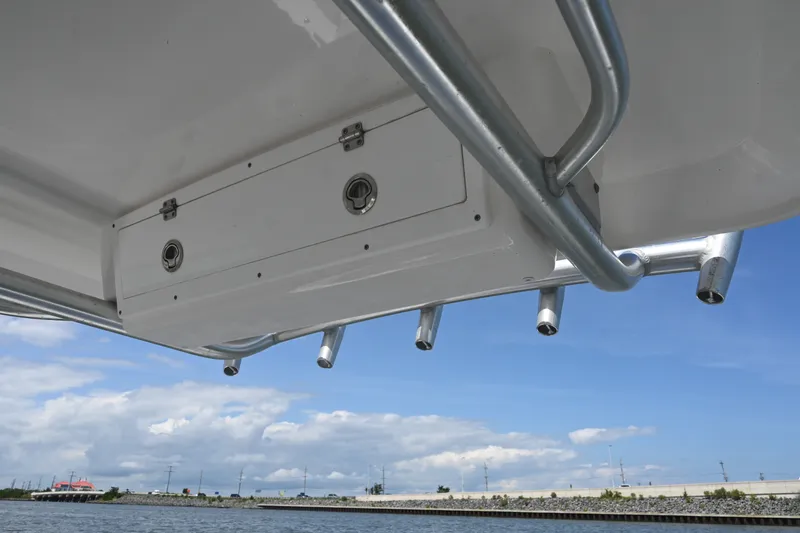 Slide: The Image of 2024 Sea Fox 228 Commander boat underside with rod holders, against a blue sky backdrop. - 29