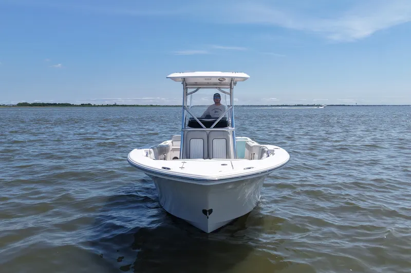 Slide: The Image of A 2024 Sea Fox 228 Commander on calm waters. A person stands at the helm. - 4