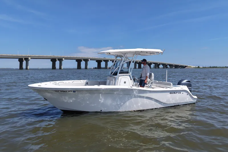 Slide: The Image of A 2024 Sea Fox 228 Commander on calm water with a bridge in the background. - 3
