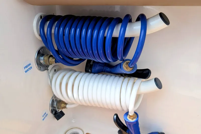 Slide: The Image of Coiled hoses on 2026 Sea Born LX22 Center Console boat, labeled fresh and raw water. - 30