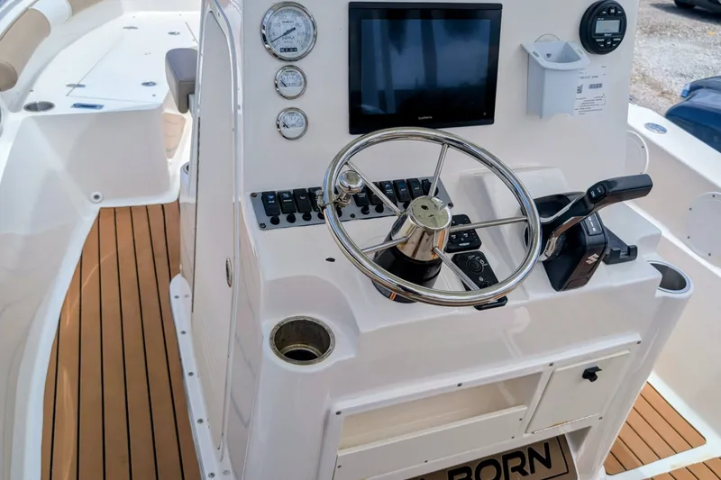 Slide: The Image of 2026 Sea Born LX22 Center Console boat dashboard with steering wheel and controls. - 14