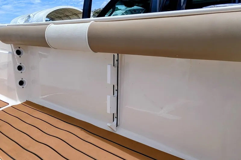 Slide: The Image of 2026 Sea Born LX22 Center Console boat interior with cushioned side panel and teak flooring. - 33