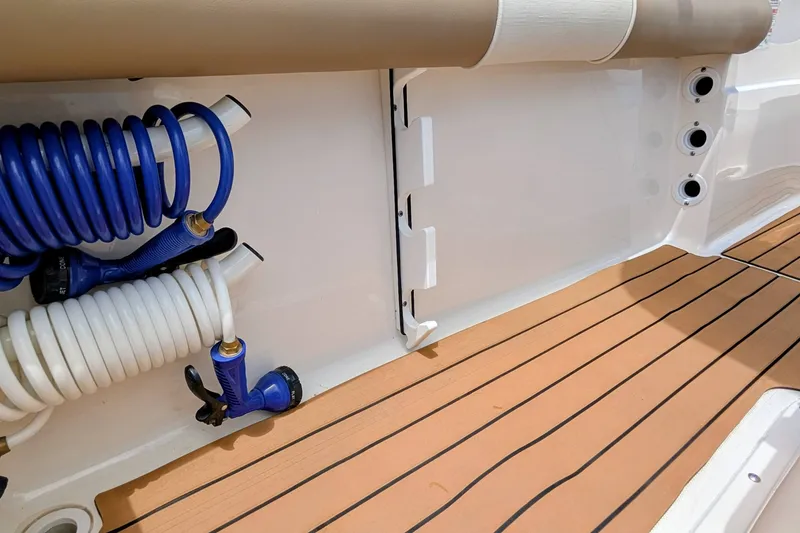 Slide: The Image of 2026 Sea Born LX22 Center Console boat deck with coiled hoses and teak flooring. - 28