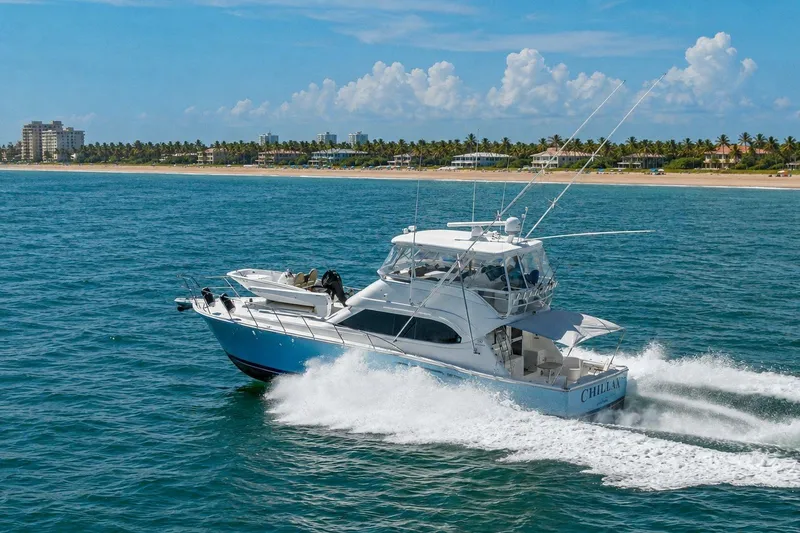 Slide: The Image of 2005 Riviera 51 Flybridge yacht cruising near a tropical coastline. - 1