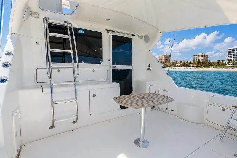 Slide: The Image of 2005 Riviera 51 Flybridge yacht deck with table, ladder, and ocean view. - 7