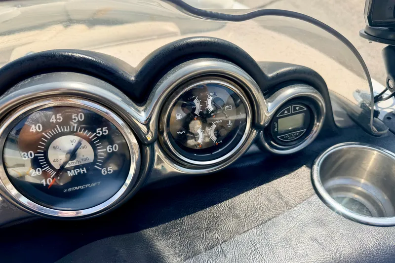 Slide: The Image of Dashboard of 2008 Starcraft Aurora Star Step 190 IO boat with gauges and cup holder. - 56
