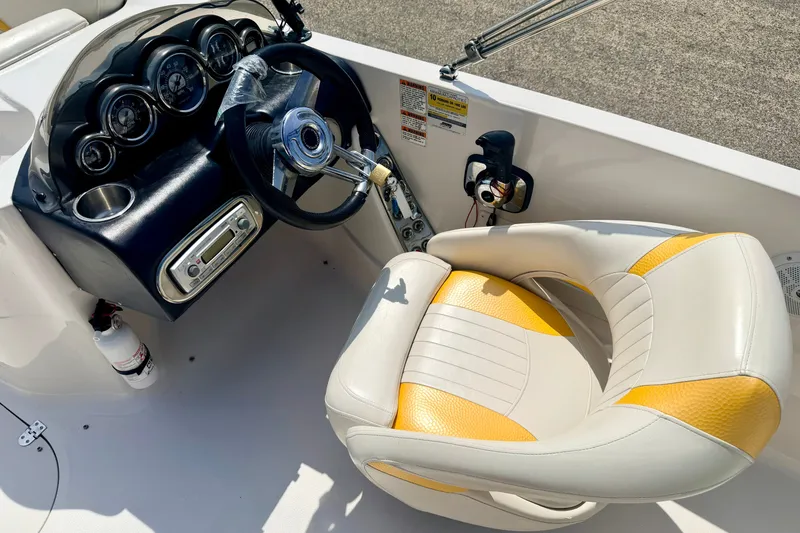 Slide: The Image of 2008 Starcraft Aurora Star Step 190 IO boat dashboard with steering wheel and yellow-accented seat. - 51