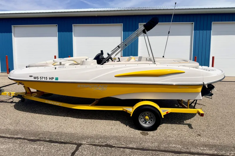 Slide: The Image of 2008 Starcraft Aurora Star Step 190 IO boat on yellow trailer, parked near blue building. - 3