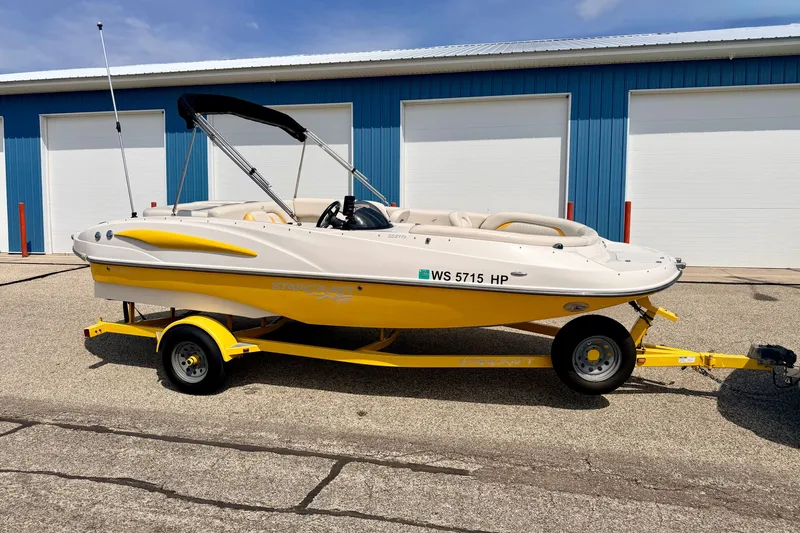 The Image of 2008 Starcraft Aurora Star Step 190 IO boat on yellow trailer, parked outdoors. - 0