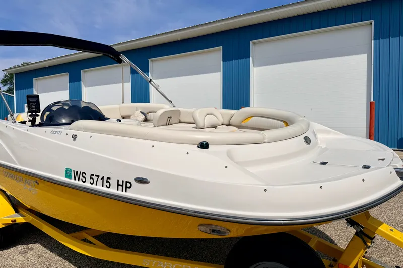Slide: The Image of 2008 Starcraft Aurora Star Step 190 IO boat with yellow hull, parked near blue building. - 17