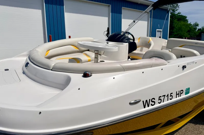Slide: The Image of 2008 Starcraft Aurora Star Step 190 IO boat with white and yellow seating, docked near blue building. - 13