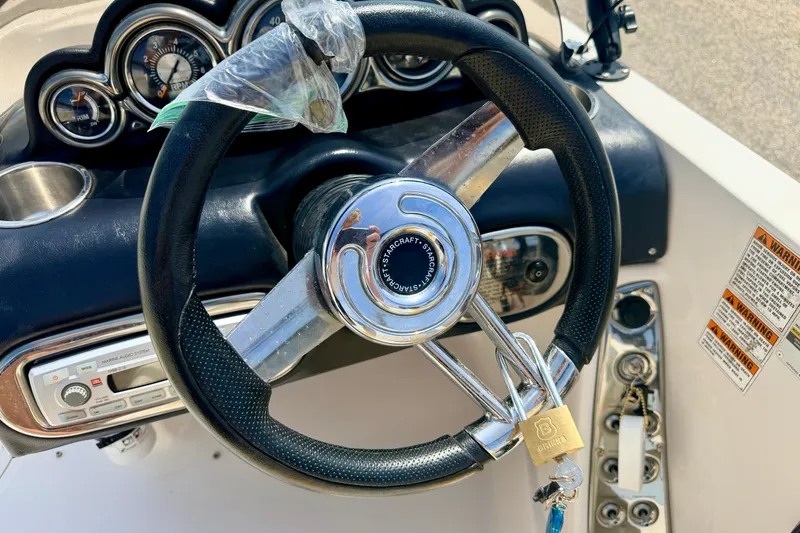Slide: The Image of Steering wheel of 2008 Starcraft Aurora Star Step 190 IO boat with dashboard controls. - 58