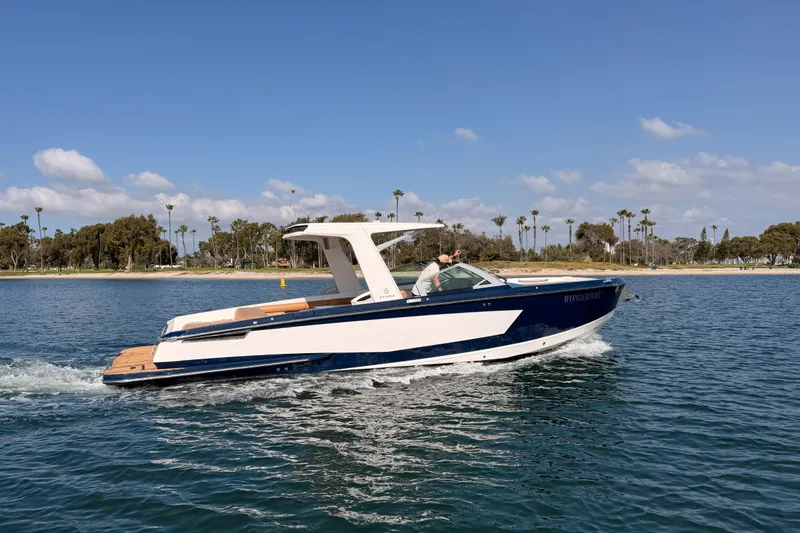Slide: The Image of 2022 Aviara AV32 I/O boat cruising on a sunny day near a scenic shoreline. - 1
