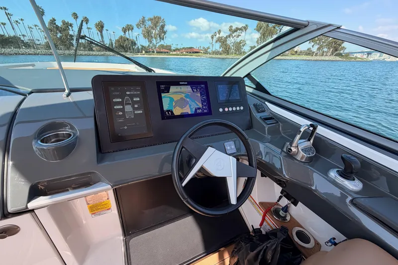 Slide: The Image of 2022 Aviara AV32 I/O boat dashboard with navigation screens, steering wheel, and water view. - 20
