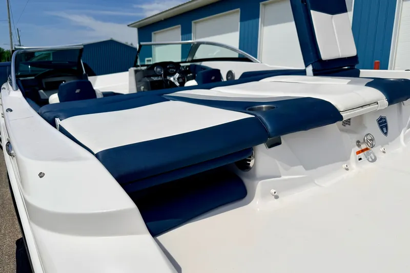 Slide: The Image of 2014 Four Winns H200 boat with blue and white seating, docked near blue buildings. - 24
