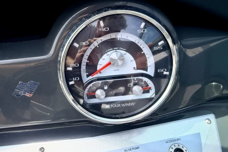 Slide: The Image of 2014 Four Winns H200 speedometer and fuel gauge on dashboard. - 54
